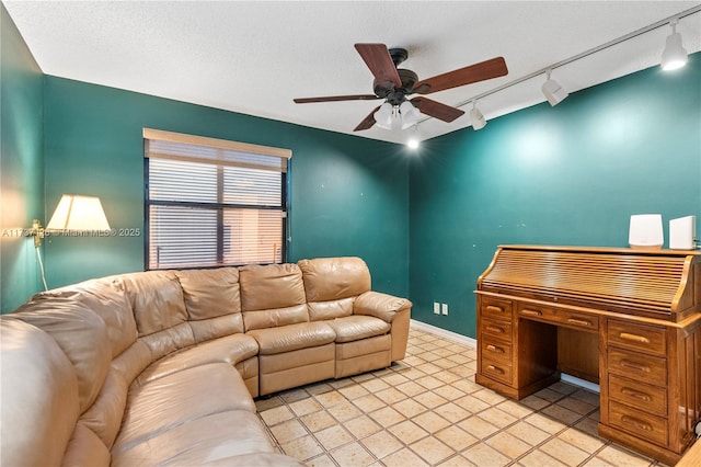 living room featuring ceiling fan and a textured ceiling