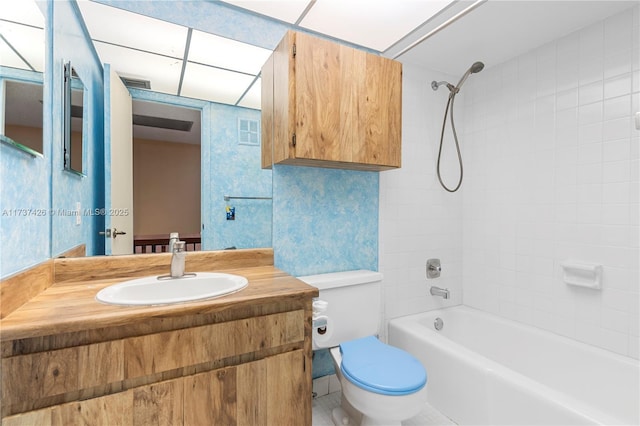 full bathroom featuring tiled shower / bath combo, vanity, and toilet