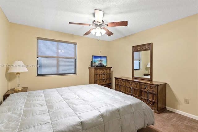 bedroom featuring ceiling fan, light colored carpet, and a textured ceiling