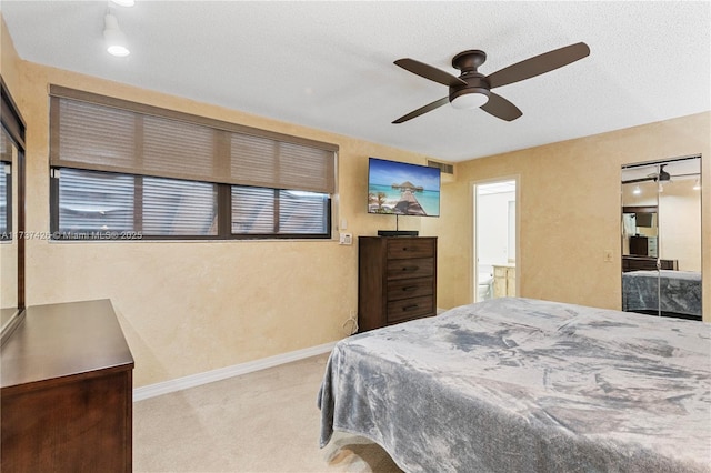 carpeted bedroom with ceiling fan and a textured ceiling