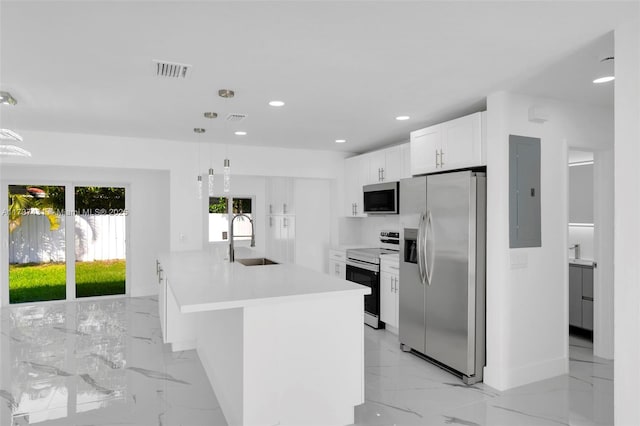 kitchen with sink, stainless steel appliances, white cabinets, decorative light fixtures, and kitchen peninsula