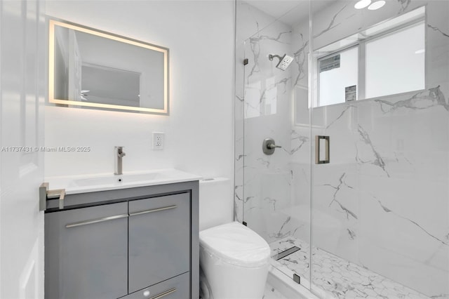 bathroom featuring a shower with door, vanity, and toilet