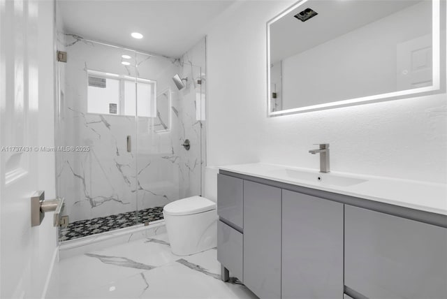 bathroom featuring vanity, toilet, and a shower with door