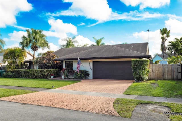 ranch-style house with a garage and a front lawn