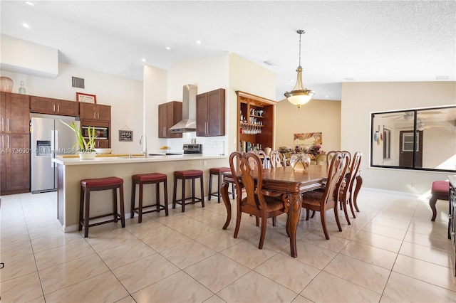 tiled dining space with lofted ceiling and sink