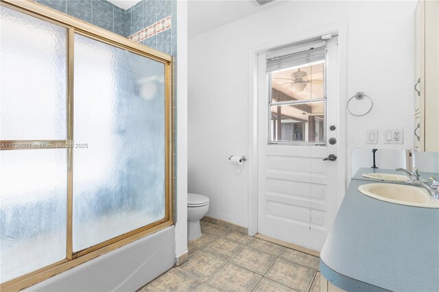 full bathroom with toilet, tile patterned floors, bath / shower combo with glass door, and sink