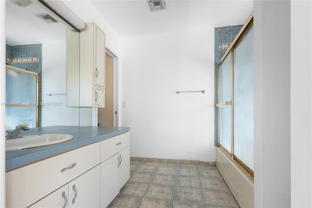 bathroom featuring bath / shower combo with glass door and vanity