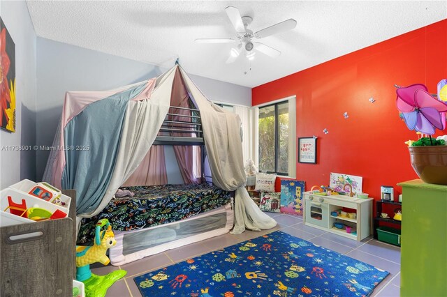 game room featuring light tile patterned floors, a textured ceiling, and ceiling fan