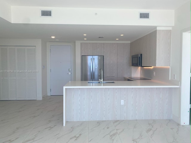 kitchen with sink, stainless steel refrigerator, and kitchen peninsula