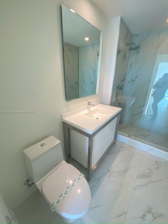 bathroom with vanity, toilet, and a tile shower