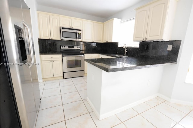 kitchen featuring appliances with stainless steel finishes, kitchen peninsula, sink, and light tile patterned floors