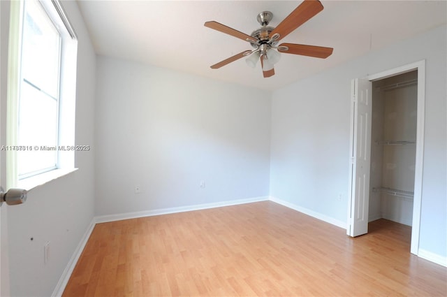 unfurnished bedroom featuring a closet, multiple windows, and light hardwood / wood-style flooring