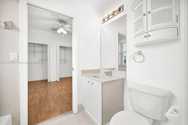 bathroom featuring vanity, ornamental molding, ceiling fan, toilet, and tile patterned floors