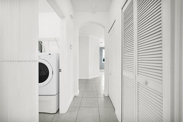 clothes washing area with washer / clothes dryer and light tile patterned floors