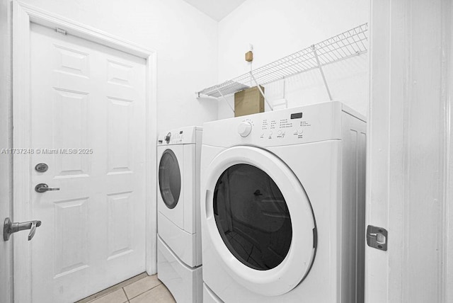 clothes washing area with light tile patterned floors and independent washer and dryer