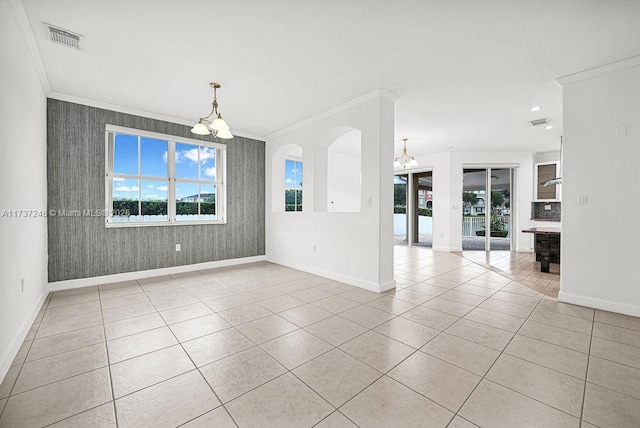 unfurnished room featuring an inviting chandelier, light tile patterned floors, crown molding, and a healthy amount of sunlight