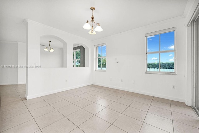 spare room with crown molding, light tile patterned flooring, and a chandelier