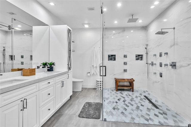 bathroom featuring toilet, vanity, and a shower with shower door