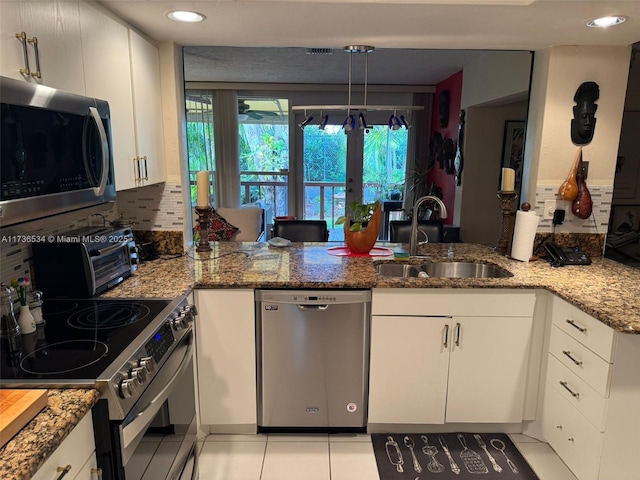 kitchen featuring stone counters, appliances with stainless steel finishes, sink, and white cabinets