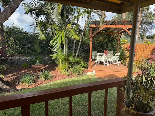 wooden deck with a yard and a pergola