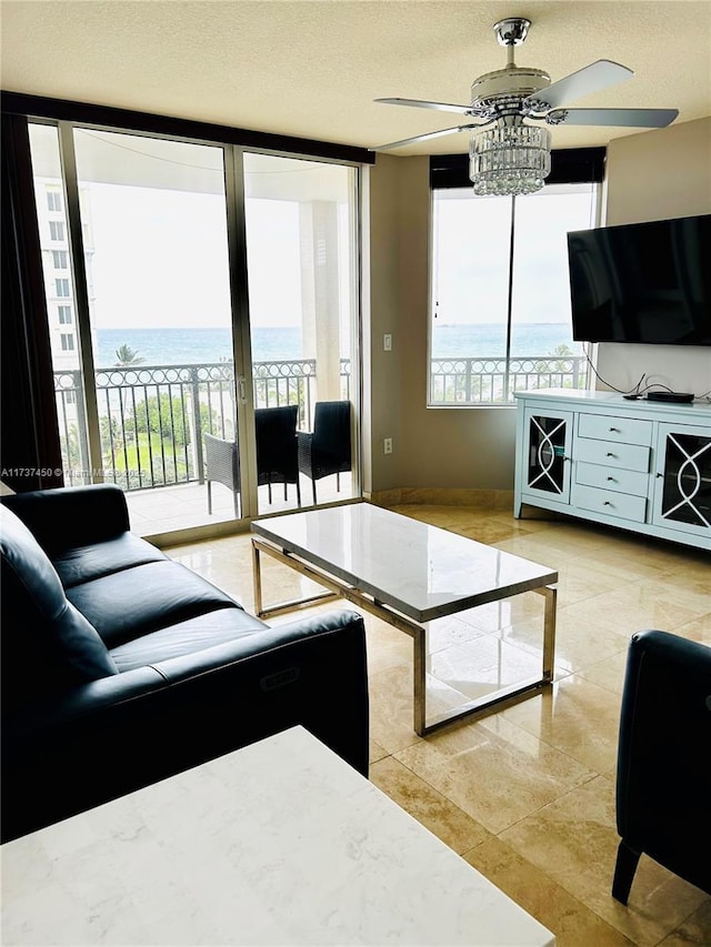 living room featuring expansive windows, ceiling fan, and a textured ceiling