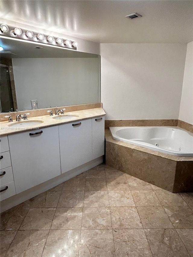 full bathroom featuring double vanity, a jetted tub, visible vents, and a sink