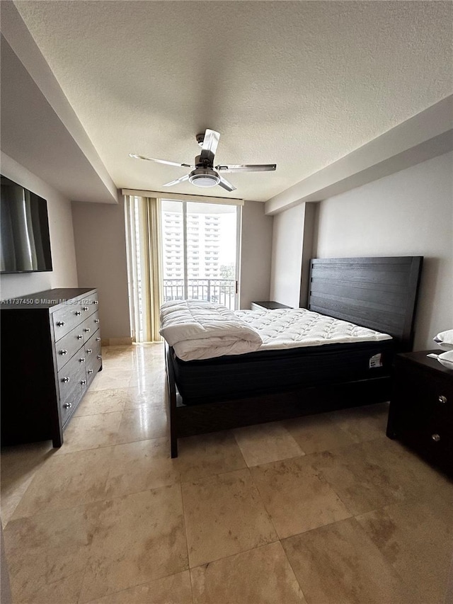 bedroom with ceiling fan and a textured ceiling