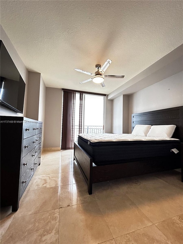 bedroom featuring a ceiling fan and a textured ceiling