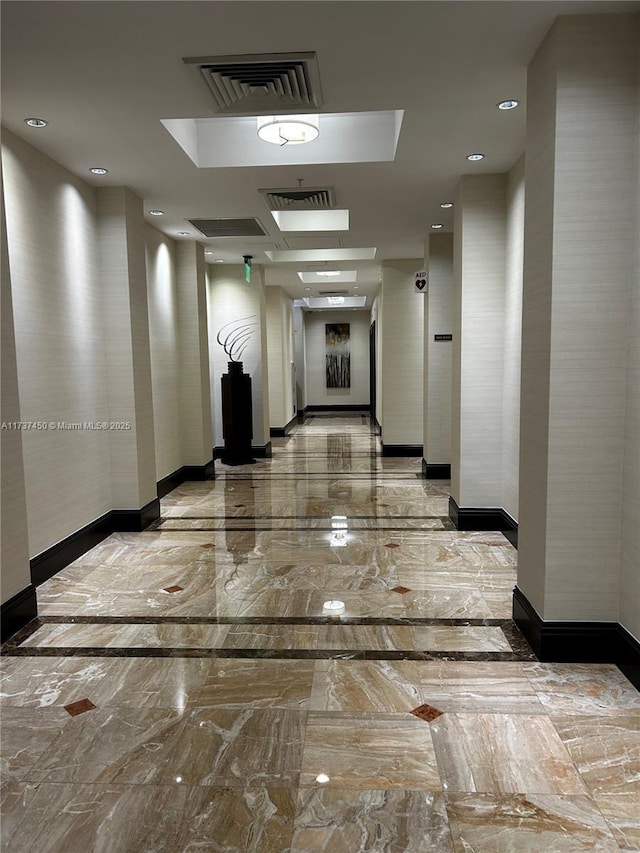 hallway with marble finish floor, recessed lighting, visible vents, and baseboards