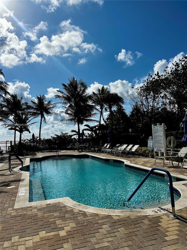 pool with a patio and fence