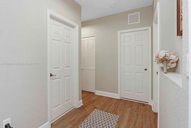 hallway with light hardwood / wood-style floors