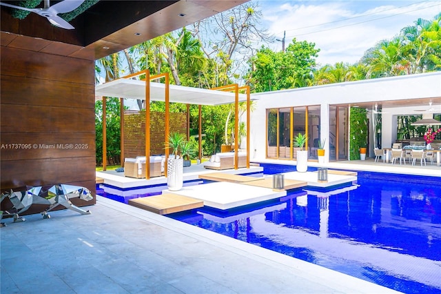 view of pool with ceiling fan and a patio area