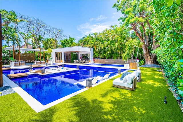 view of swimming pool featuring an outbuilding, a yard, and a jacuzzi