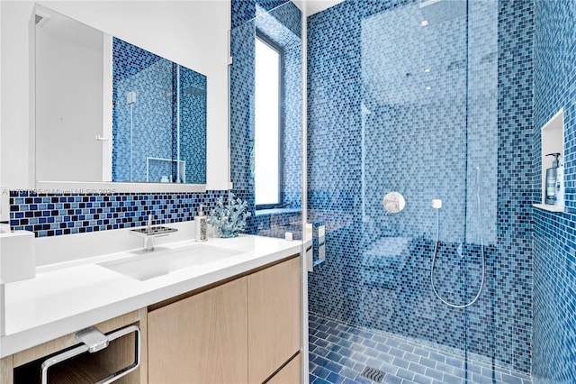 bathroom featuring vanity, tasteful backsplash, and a tile shower