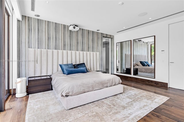 bedroom with access to exterior and wood-type flooring