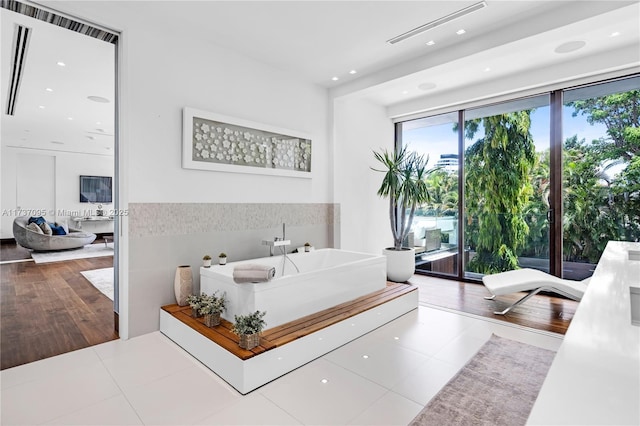 bathroom with tile patterned floors and a tub to relax in