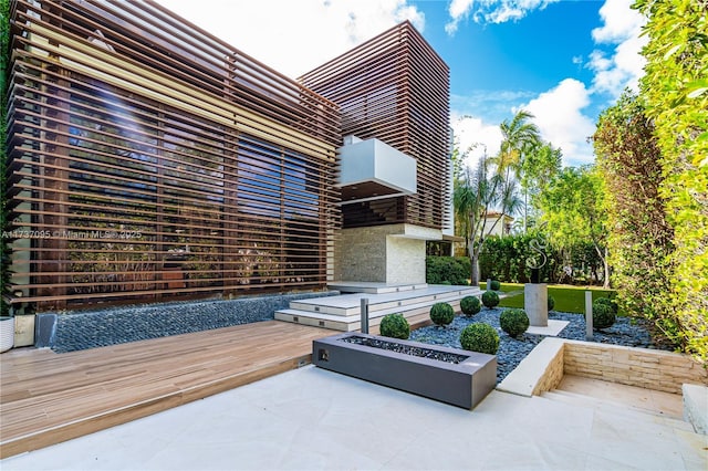 view of patio / terrace with an outdoor fire pit and a deck