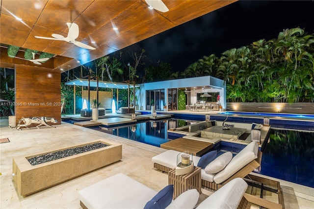 view of swimming pool with ceiling fan, a patio, and an outdoor living space with a fire pit