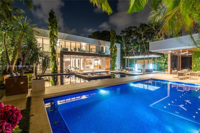 view of pool with a hot tub, an outdoor structure, and a patio