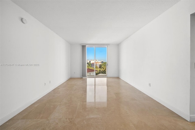 unfurnished room featuring expansive windows and a textured ceiling