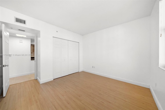 unfurnished bedroom featuring a closet and light wood-type flooring