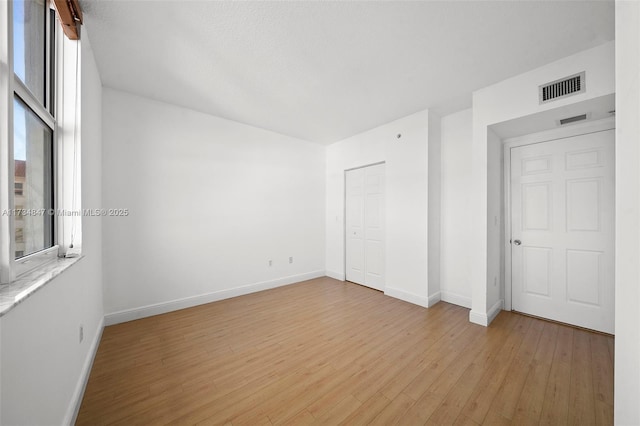 unfurnished bedroom with light hardwood / wood-style floors and a closet