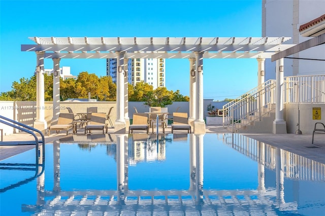 view of swimming pool featuring a water view, a pergola, and a patio area