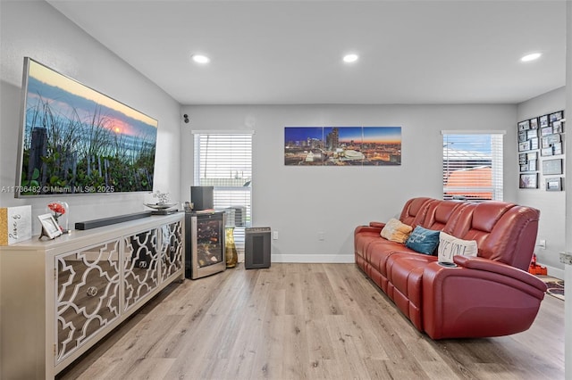 living room featuring a wealth of natural light, beverage cooler, and light hardwood / wood-style floors