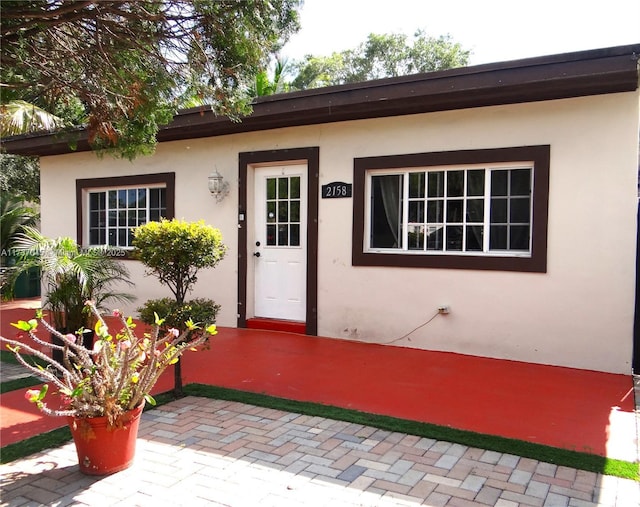 view of exterior entry with a patio