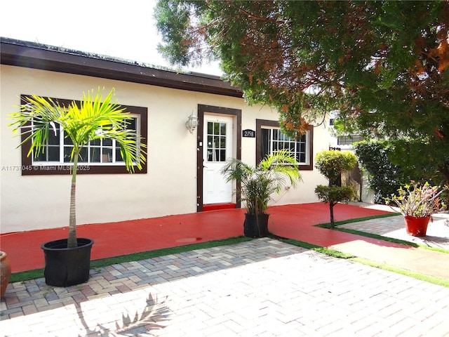 view of exterior entry featuring a patio area