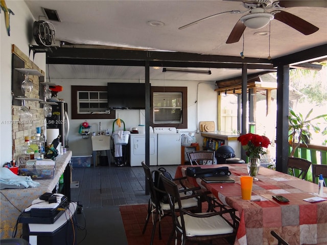 dining area with sink, washing machine and clothes dryer, and ceiling fan