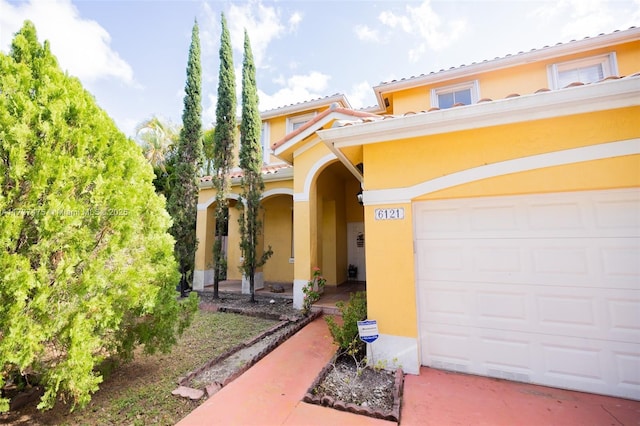 mediterranean / spanish-style house with a garage