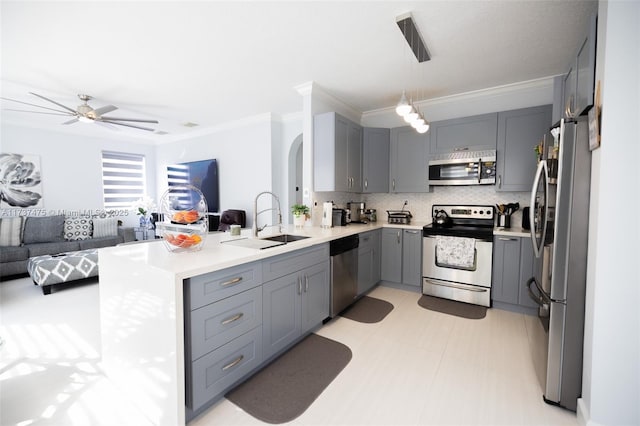 kitchen featuring sink, hanging light fixtures, appliances with stainless steel finishes, gray cabinets, and backsplash