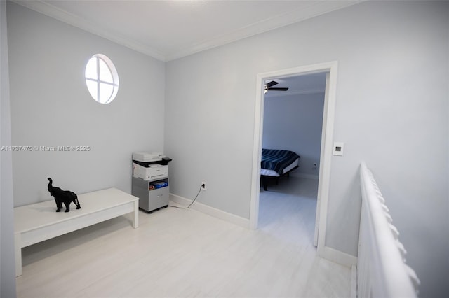 interior space featuring crown molding, a walk in closet, and light hardwood / wood-style floors